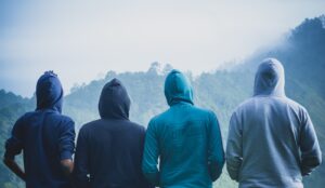 quatre personnes portant des pulls à capuche