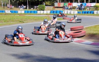 Plusieurs pilotes en kart sur une piste équipée de pneus de délimitation bleus