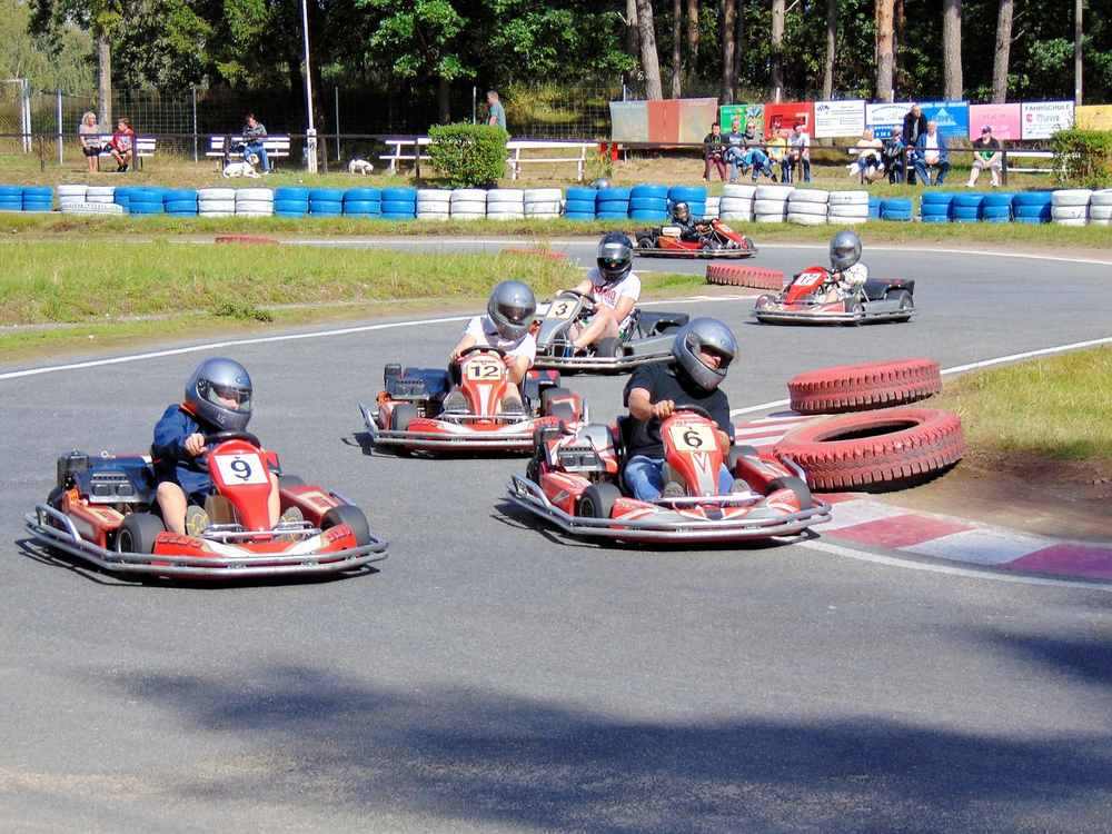 Plusieurs pilotes en kart sur une piste équipée de pneus de délimitation bleus