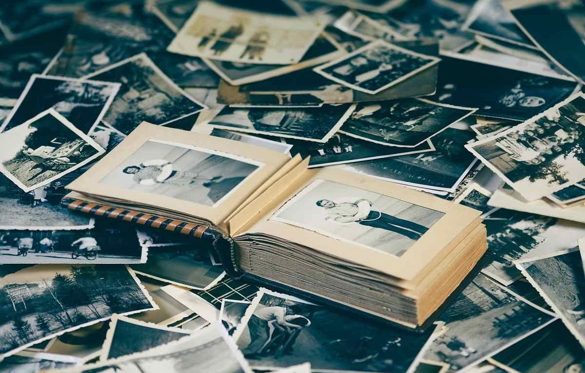 Un album ouvert entoure des photographies anciennes dispersées autour