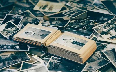 Un album ouvert entoure des photographies anciennes dispersées autour