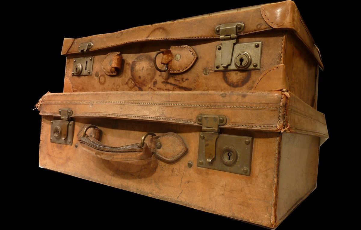 Deux vieilles valises en cuir empilées, fermetures métalliques visibles