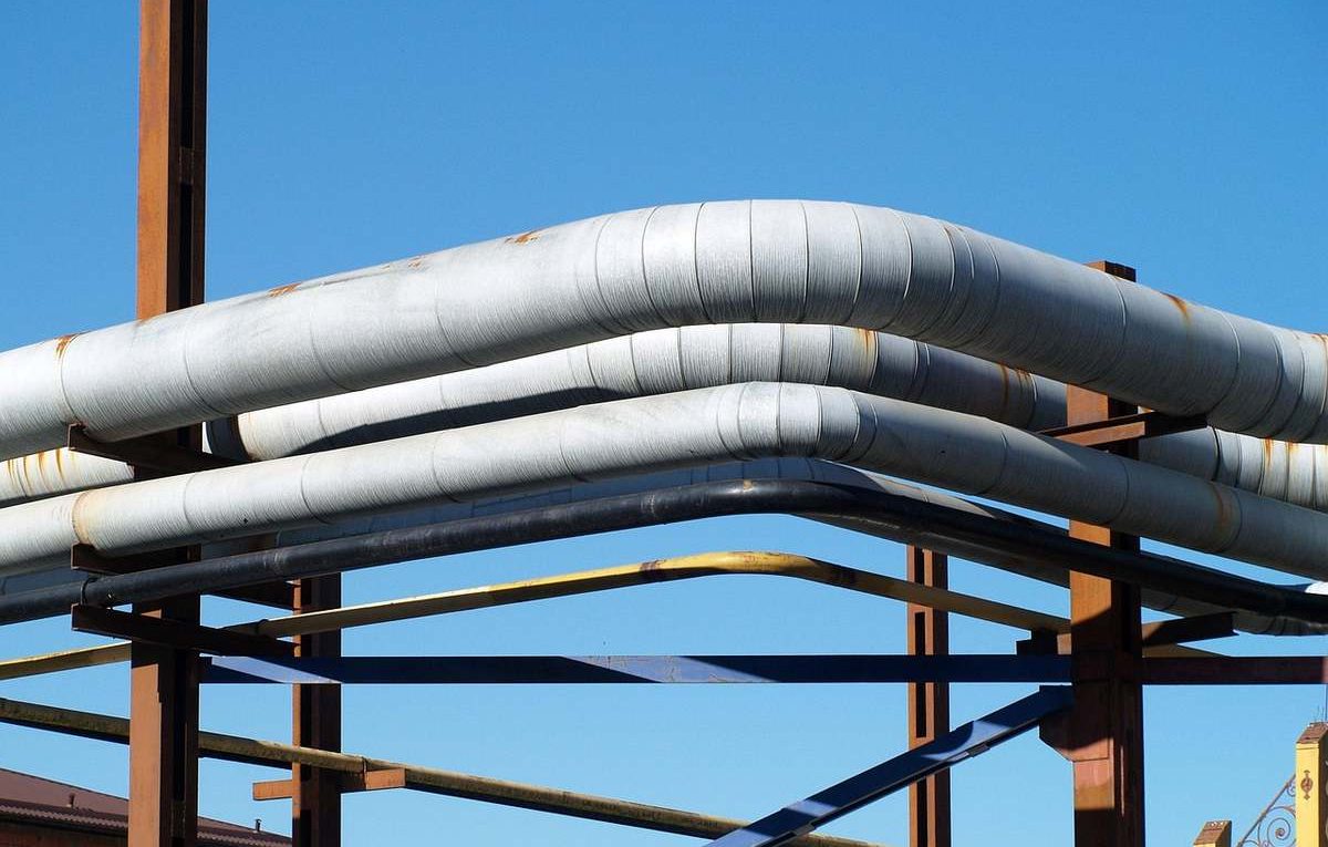 Des tuyaux blancs sur une structure métallique sous un ciel bleu